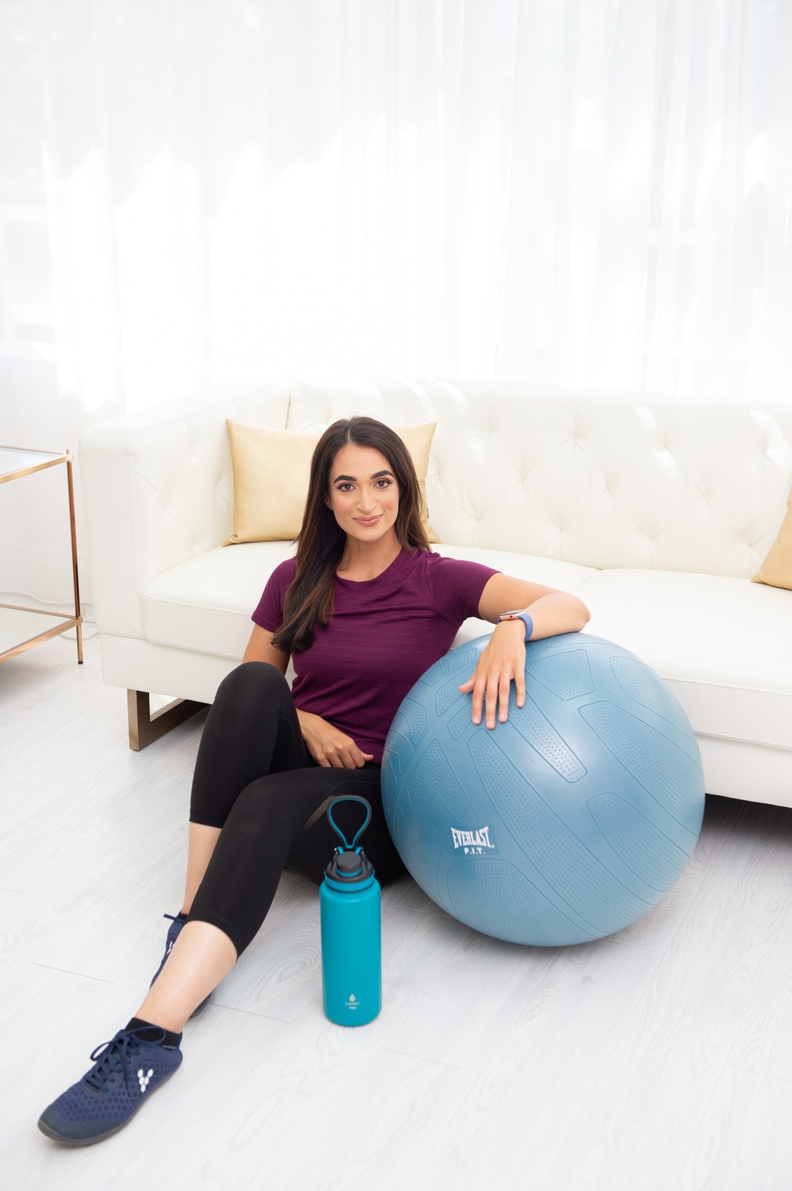 Salwa Qadir beside a stability ball and water bottle